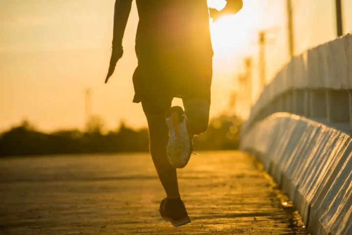 Silhouette of a young fitness man running on sunrise